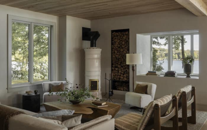 Cozy living room with antique elm wood cladding and a coffee table in a sustainable home overlooking a lake